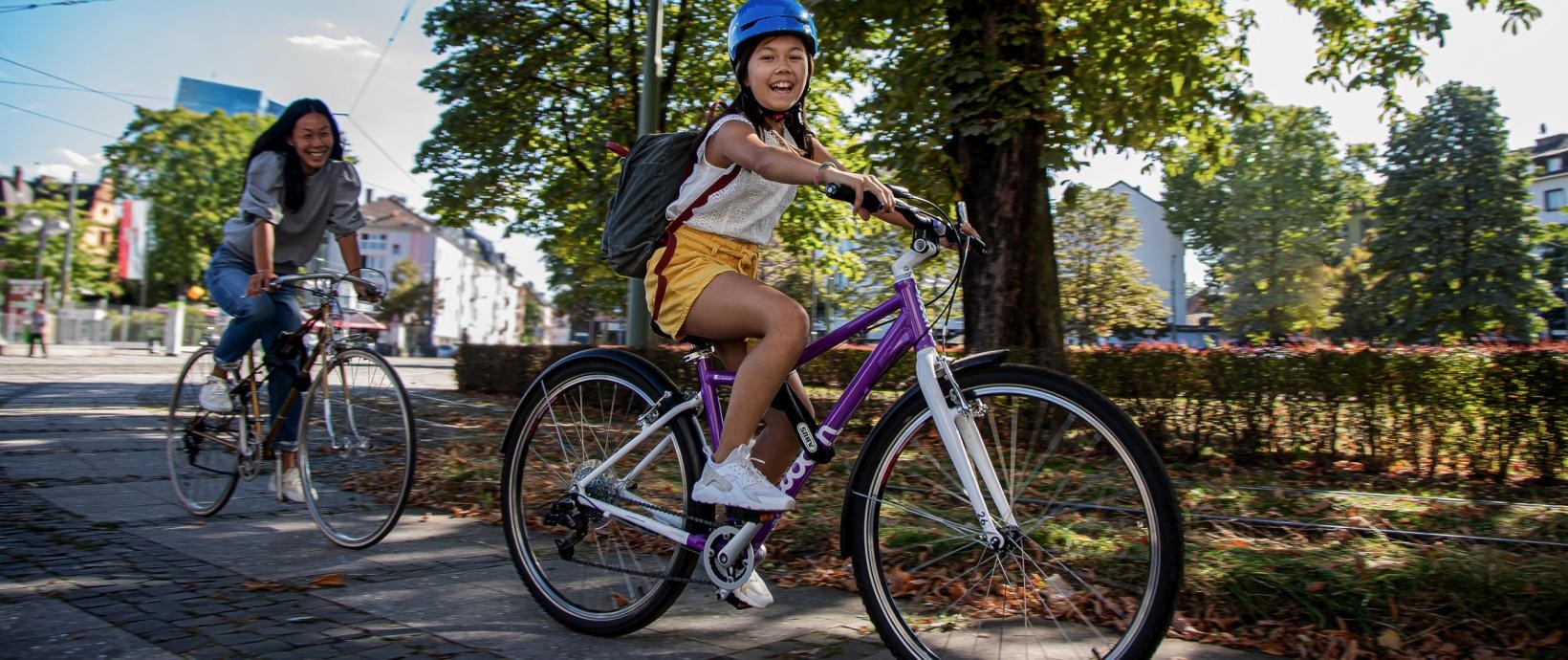 junge Frau und Mädchen mit Helm beim Radfahren